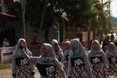 Mahalle sakinleri ve öğrenciler, Yol boyunca yürüyüşler le, İslami okul mezuniyet anma kutluyoruz. Müzik performansları ve bayrak çekme ile Batang / Endonezya, Haziran 22, 2019