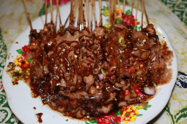 Sate Madura, fıstık sosu şeklinde Sambal ile verilen tavuk Satay, biber ve soğurma dilimleri bir yağmurlama ile, yenmeye hazır