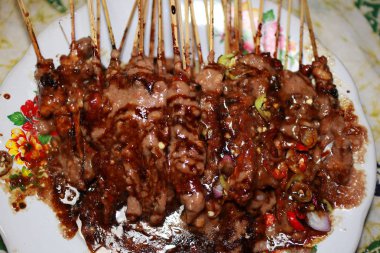 Sate Madura, fıstık sosu şeklinde Sambal ile verilen tavuk Satay, biber ve soğurma dilimleri bir yağmurlama ile, yenmeye hazır