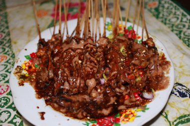 Sate Madura, fıstık sosu şeklinde Sambal ile verilen tavuk Satay, biber ve soğurma dilimleri bir yağmurlama ile, yenmeye hazır