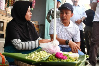 Old Indonesian women, selling various colorful flowers on the street market for religious ceremonies or decorations, at Batang Indonesia, 21 September 2019