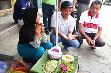 Old Indonesian women, selling various colorful flowers on the street market for religious ceremonies or decorations, at Batang Indonesia, 21 September 2019
