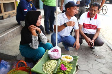 Old Indonesian women, selling various colorful flowers on the street market for religious ceremonies or decorations, at Batang Indonesia, 21 September 2019