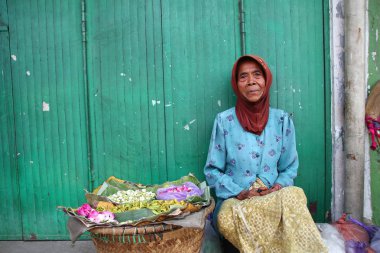 Old Indonesian women, selling various colorful flowers on the street market for religious ceremonies or decorations, at Batang Indonesia, 21 September 2019