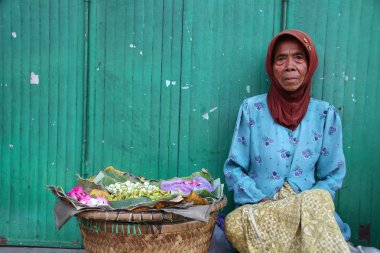 Old Indonesian women, selling various colorful flowers on the street market for religious ceremonies or decorations, at Batang Indonesia, 21 September 2019