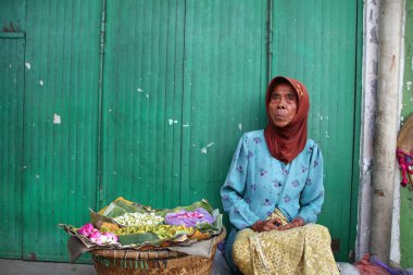 Old Indonesian women, selling various colorful flowers on the street market for religious ceremonies or decorations, at Batang Indonesia, 21 September 2019