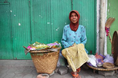 Old Indonesian women, selling various colorful flowers on the street market for religious ceremonies or decorations, at Batang Indonesia, 21 September 2019