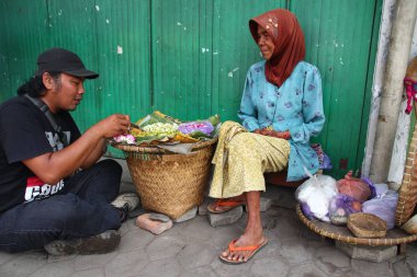 Old Indonesian women, selling various colorful flowers on the street market for religious ceremonies or decorations, at Batang Indonesia, 21 September 2019