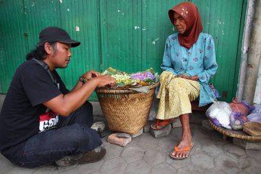 Old Indonesian women, selling various colorful flowers on the street market for religious ceremonies or decorations, at Batang Indonesia, 21 September 2019
