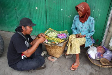 Old Indonesian women, selling various colorful flowers on the street market for religious ceremonies or decorations, at Batang Indonesia, 21 September 2019
