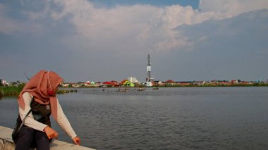  Odaklanamayan, bulanık seçici odak ve gürültü görüntüsü. Bir adam 14 Haziran 2020 'de Pekalongan Endonezya gölünde balık yakalamak için ağ kullanır.