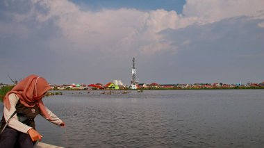  Odaklanamayan, bulanık seçici odak ve gürültü görüntüsü. Bir adam 14 Haziran 2020 'de Pekalongan Endonezya gölünde balık yakalamak için ağ kullanır.