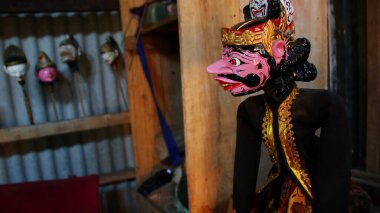 Seçici bir odak görüntüsü, Wayang Golek, çeşitli karakterlere sahip ahşap oyulmuş bir kukla şeklinde. Düşük ışık ve gürültü görüntüsüyle fotoğraflandı.