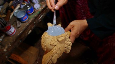 Seçici bir odak görüntüsü, Wayang Golek, çeşitli karakterlere sahip ahşap oyulmuş bir kukla şeklinde. Düşük ışık ve gürültü görüntüsüyle fotoğraflandı.