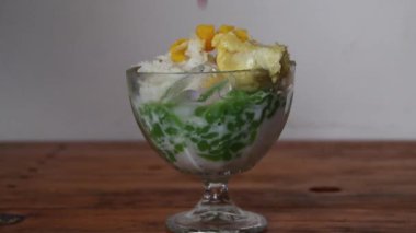 Gürültü, film tahıl videosu. Tatlı palmiye şekeriyle sulanan Cendol dawet glutinous pilavından iç.