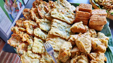 Geleneksel Endonezya usulü kızarmış atıştırmalıklara yakın Tempeh, sebzeli börek ve kızarmış tofu dahil. Muz yaprağı tabağında servis edilen popüler sokak yemekleri, çıtır çıtır ve lezzetli..