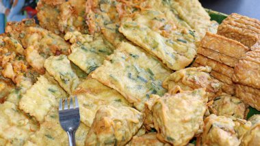 Geleneksel Endonezya usulü kızarmış atıştırmalıklara yakın Tempeh, sebzeli börek ve kızarmış tofu dahil. Muz yaprağı tabağında servis edilen popüler sokak yemekleri, çıtır çıtır ve lezzetli..