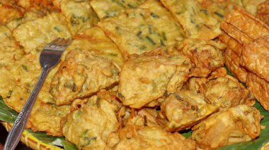 Geleneksel Endonezya usulü kızarmış atıştırmalıklara yakın Tempeh, sebzeli börek ve kızarmış tofu dahil. Muz yaprağı tabağında servis edilen popüler sokak yemekleri, çıtır çıtır ve lezzetli..