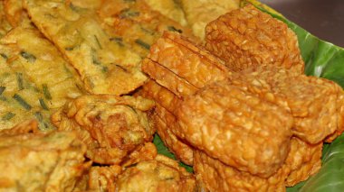 Geleneksel Endonezya usulü kızarmış atıştırmalıklara yakın Tempeh, sebzeli börek ve kızarmış tofu dahil. Muz yaprağı tabağında servis edilen popüler sokak yemekleri, çıtır çıtır ve lezzetli..