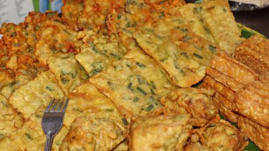 Geleneksel Endonezya usulü kızarmış atıştırmalıklara yakın Tempeh, sebzeli börek ve kızarmış tofu dahil. Muz yaprağı tabağında servis edilen popüler sokak yemekleri, çıtır çıtır ve lezzetli..