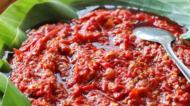 Çekirdekli ve baharatlı otantik Endonezya biberi kaşıkla taze muz yaprağı üzerinde servis edilir. Geleneksel Asya acı sosu, baharatlı sos ve egzotik mutfak baharatı..