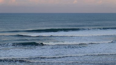 Huzurlu okyanus dalgaları kıyıda köpüklü sörf ve sakin ufuklarla kırılıyor. Seyahat, doğa, meditasyon, deniz manzarası, kıyı geçmişleri, yaz tatili ve çevre kavramları için mükemmel..