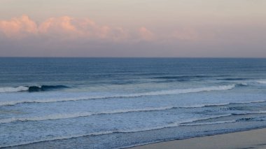 Huzurlu okyanus dalgaları kıyıda köpüklü sörf ve sakin ufuklarla kırılıyor. Seyahat, doğa, meditasyon, deniz manzarası, kıyı geçmişleri, yaz tatili ve çevre kavramları için mükemmel..