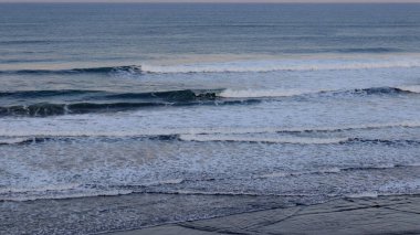 Huzurlu okyanus dalgaları kıyıda köpüklü sörf ve sakin ufuklarla kırılıyor. Seyahat, doğa, meditasyon, deniz manzarası, kıyı geçmişleri, yaz tatili ve çevre kavramları için mükemmel..