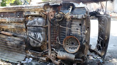 Yanan araba enkazı, büyük hasar, erimiş parçalar ve yok oluşu göstererek yangından sonra terk edilmiş. Kazaları, felaketleri, güvenlik risklerini ve sigorta temalarını resmetmek için mükemmel.