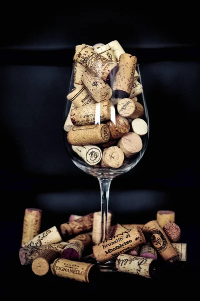 corks poured into a wine glass on a dark background