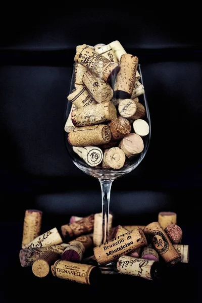 Corks poured into a wine glass on a dark background — Stock Photo, Image