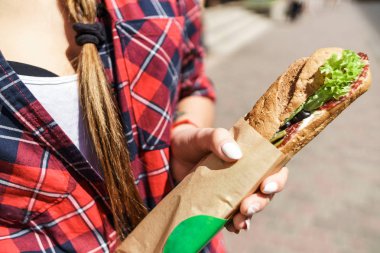 bir sandviç tutarak el