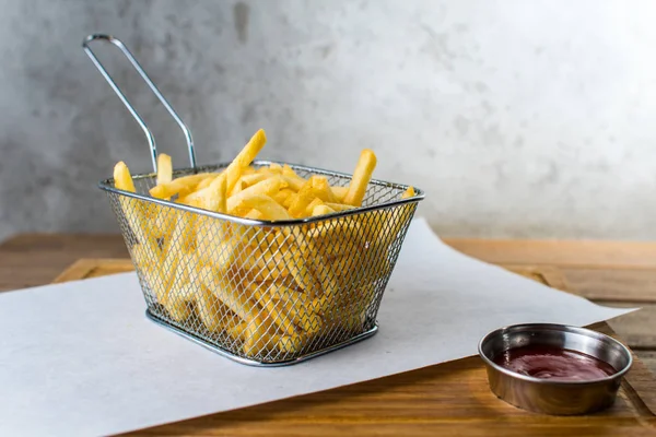 patates kızartması demir ızgara ve sosu bir ahşap masa gri arka plan üzerinde