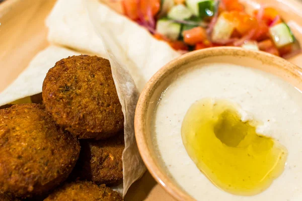falafel salata ve ahşap bir masa üzerine sos ile