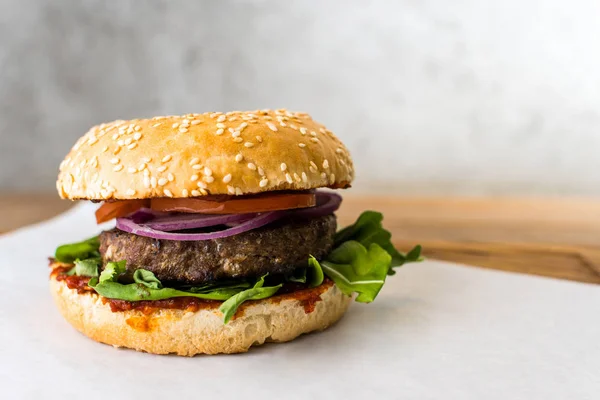 Hamburguesa picante sobre fondo gris mesa de madera Imagen De Stock