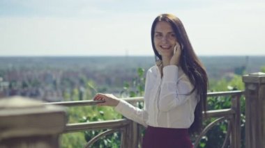 güneşli gün, güzel esmer iş kadını ufukta karşı telefonda konuşurken