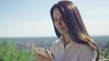 güneşli gün, güzel esmer iş kadını ufukta karşı telefonda konuşurken