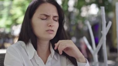 güneşli gün, bir restoranda güzel bir esmer iş kadını bir tatlı ve mokachino sahiptir, ama bir şey yanlış diş ağrısı gitti