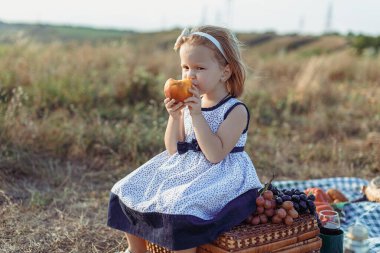 Sonbahar, küçük kızıl saçlı kız şeftali yer.