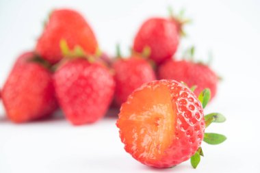 Beyaz arka plandaki parıltıdan birkaç çilek çıkartılır.