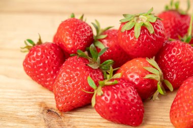 Tahta masada bir sürü taze çilek var.