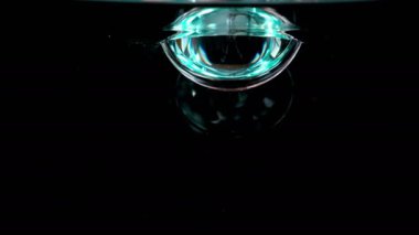 Genç erkek yavaş yavaş kristal berraklığında suya boş cam koyar. Cam suyla doluyor ve insancadan sonra camı sudan çıkarıyor..