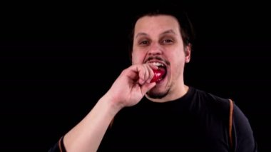 Sakallı genç çekici erkek tutkuyla taze ve çiğ kırmızı biber içine ısırır.