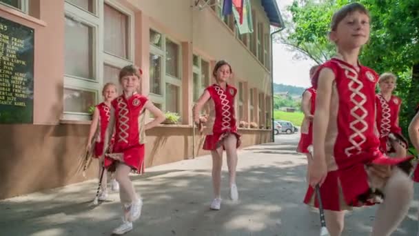 女孩们穿着红色服装 正在用她们的主要棍子练习 这是发生在学校的院子里 — 图库视频影像