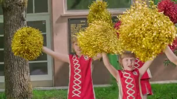 Grundschülerinnen Halten Gelbe Und Rote Bommelmützen Der Hand Und Üben — Stockvideo