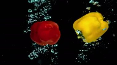 Ham kırmızı ve sarı biber aniden taze kristal berraklığında suya düşmek.