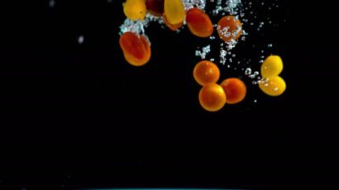 Sulu ve renkli küçük domates zarif taze kristal berraklığında su tencereye düşmek.