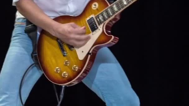 年轻塑造的男性热情地弹奏五颜六色的电吉他 娱乐观众 — 图库视频影像