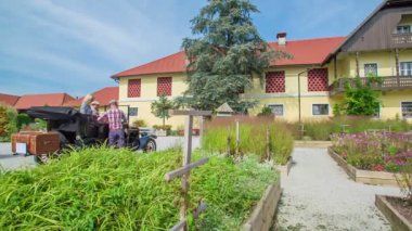 Genç bir adam kız arkadaşı vintage araba çıkmak yardımcı oluyor ve sonra çift sarılma. Büyük sarı bir çiftlik evi arka planda.