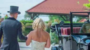 Genç bir çift evlenmek üzere. Onlar bir Vintage araba yaklaşıyor ve genç bir adam arabada kapıyı açıyor ve onu arabaya almak yardımcı oluyor.